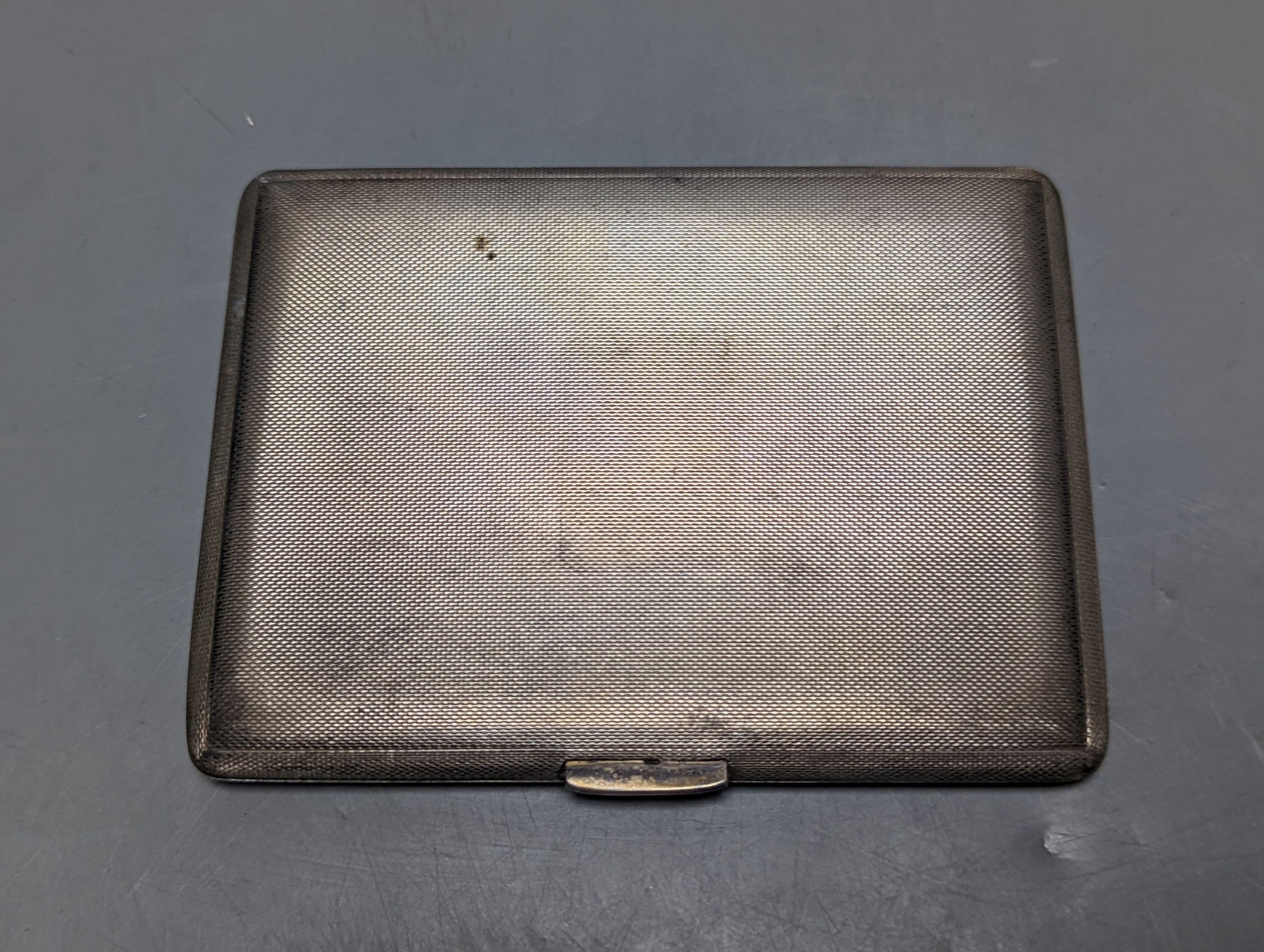 A George V engine turned silver cigarette case, 11.3cm, together with an 800 standard white metal mounted cigarette box.